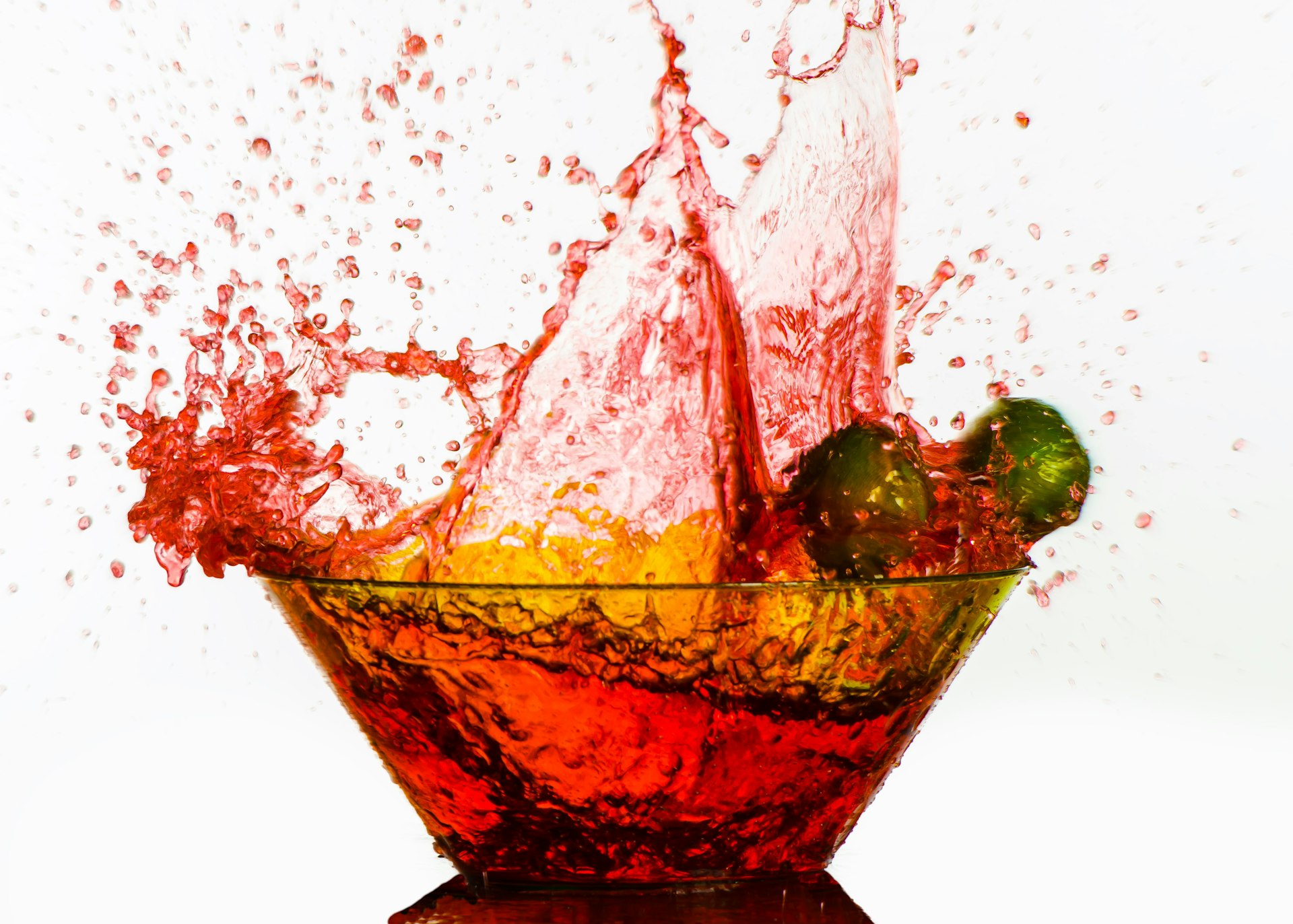 A glass bowl filled with oranges and limes